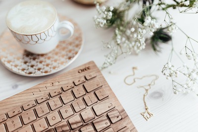 kaboompics_Wooden keyboard, coffee and golden jewellery