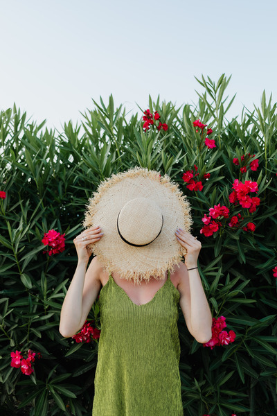 kaboompics_A smiling woman in a summer hat with pink flowers (1)