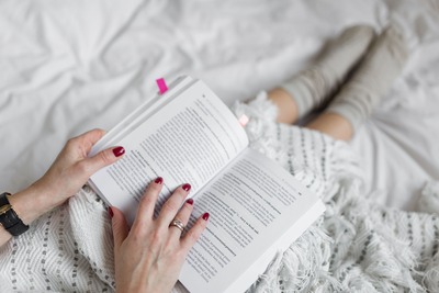 kaboompics_Soft photo of woman on the bed with the book